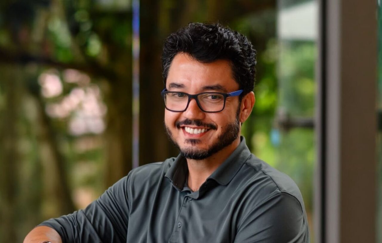 João Toledo, psicanalista e mentor, sorrindo em um ambiente com luz natural