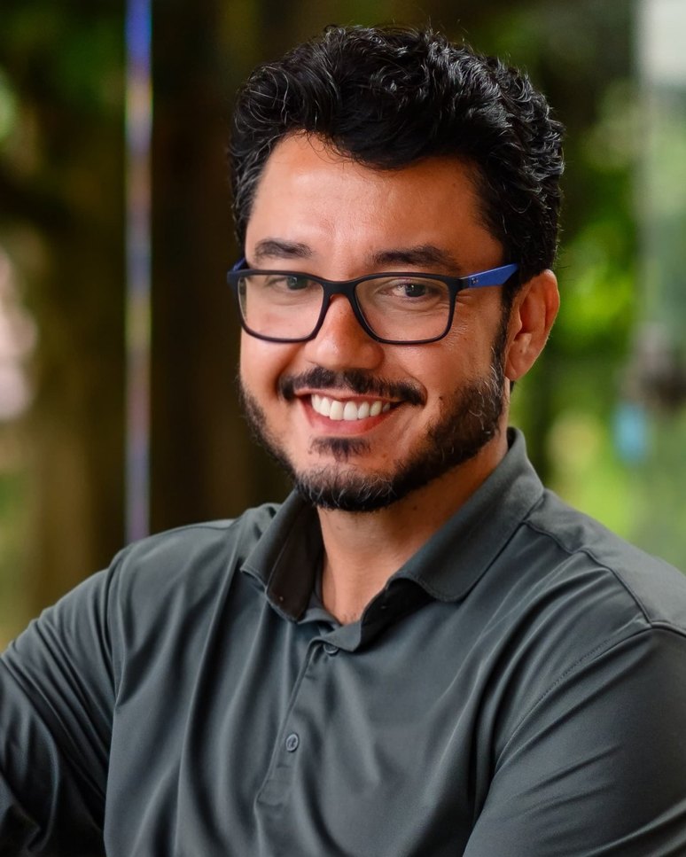 João Toledo sorrindo, sentado